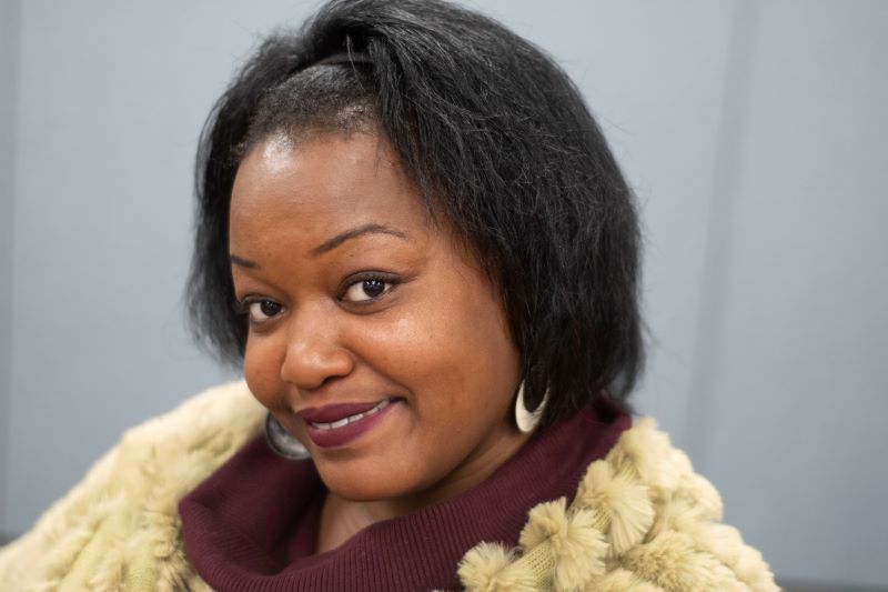 Woman in fur coat smiling warmly