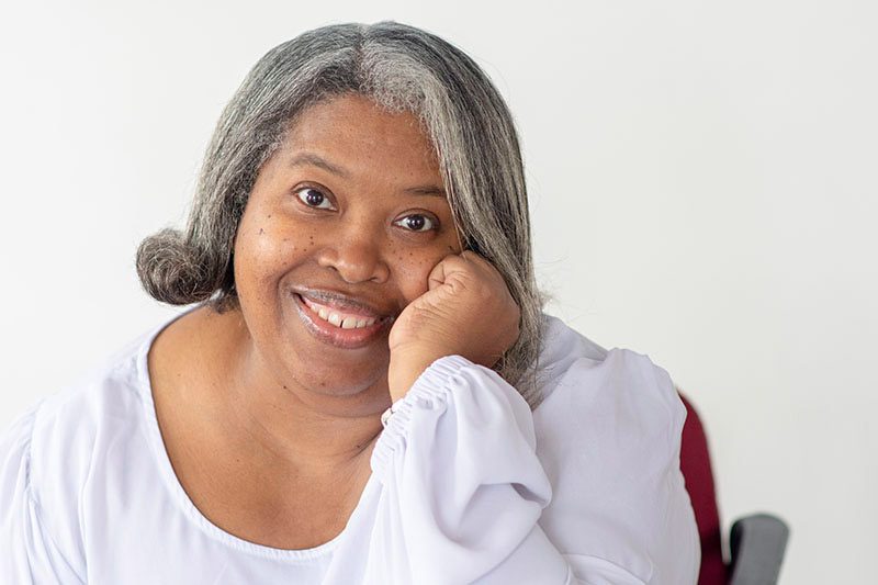 Smiling woman with hand on cheek