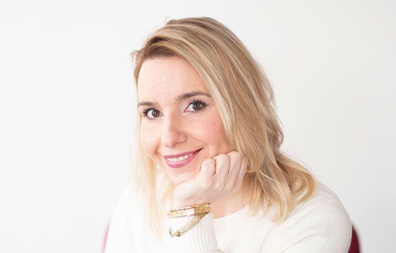 Woman in white sweater smiling